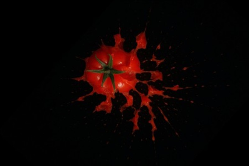 Dramatisk Tomatsprøjt i Sort - Oplev den imponerende energi i denne tomat, der sprøjter saft ud i et eksplosivt øjeblik mod en mørk baggrund. Dette kunstværk tilføjer en livlig og dynamisk følelse til dit rum.